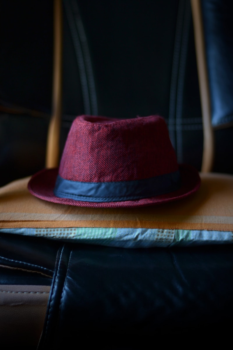 a red hat sitting on top of a piece of luggage
